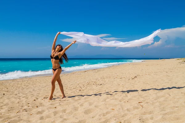 Mooi meisje met witte stof op het strand. — Stockfoto