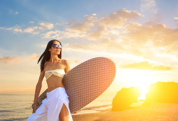 Asiatisk kvinna med surfbräda på stranden — Stock fotografie