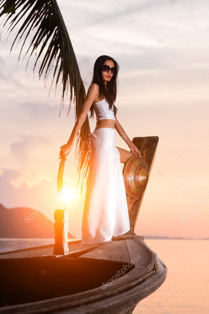 Woman on long tailed wooden boat holding a knife