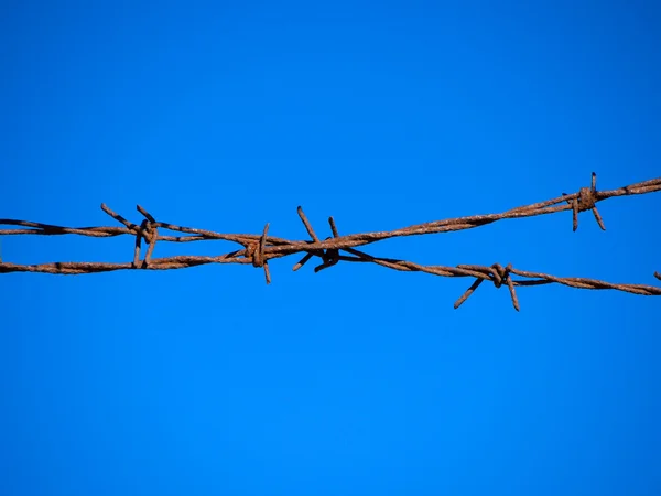 Barb wire fence and blue sky — ストック写真