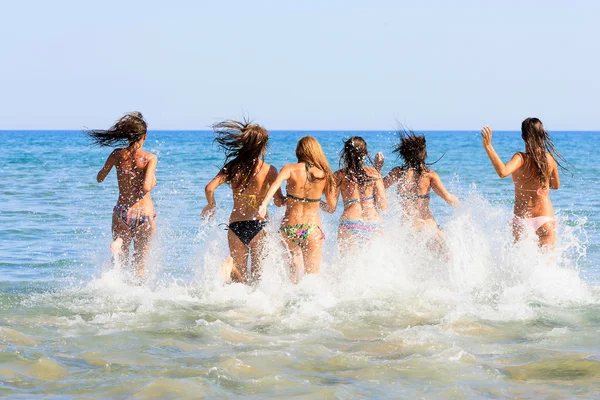 Group of six beautiful young girls running in the sea — Stock Photo, Image