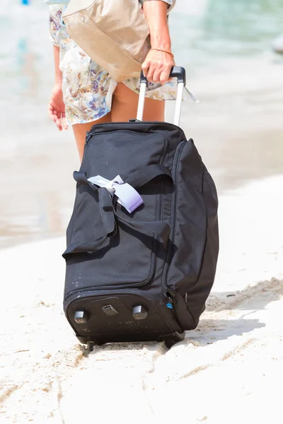 Vacaciones Mujer arrastrando su maleta en la playa — Foto de Stock