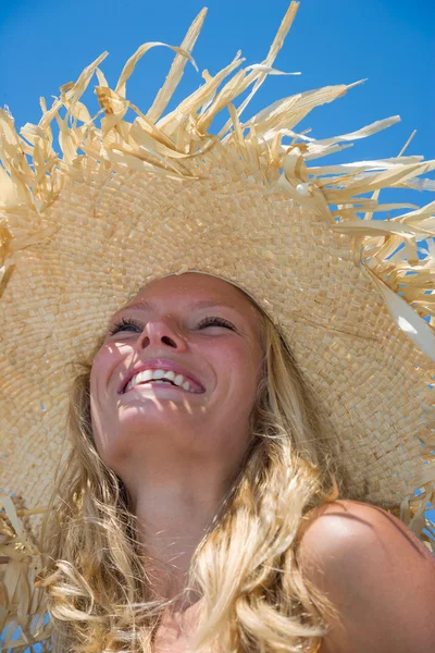 Rubia usando sombrero de paja en una hermosa playa soleada — Foto de Stock