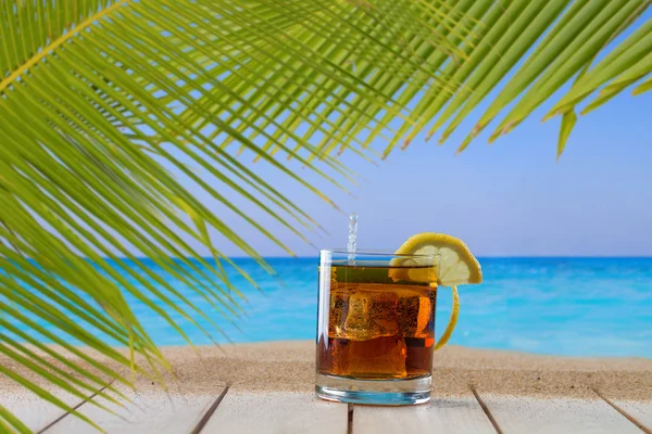 在海滩上的冰块威士忌酒玻璃 — 图库照片