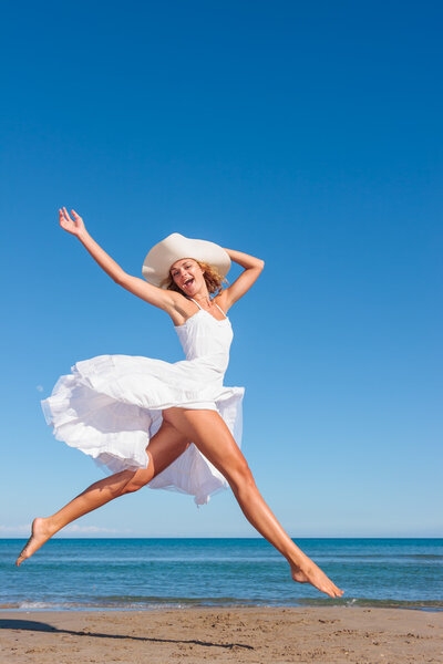 Young woman in white dress on the beach