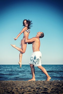 mutlu genç bir çift güzel plaj eğlenin