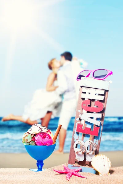 Icecream op het strand met het jonge paar kussen — Stockfoto