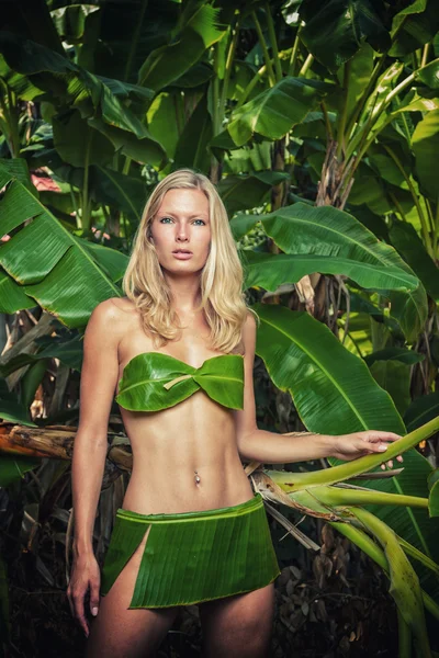 Jonge blonde vrouw poseren met bananenbladeren — Stockfoto