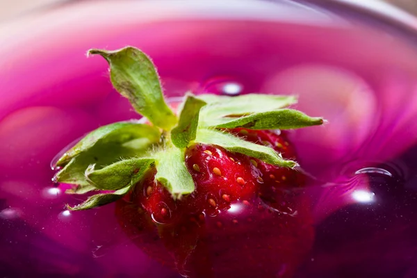 Close up of a strawberry flotting in drink — Stock Photo, Image