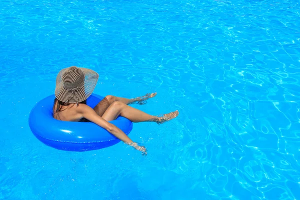 Mujer joven relajándose en la piscina — Foto de Stock