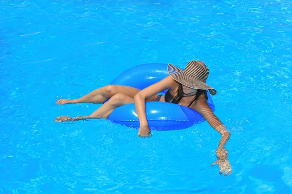 Νεαρή γυναίκα χαλαρώνοντας στην πισίνα — Φωτογραφία Αρχείου