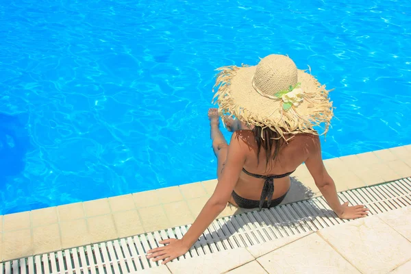 Jeune femme se relaxant à la piscine — Photo