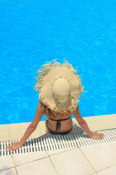 Jeune femme se relaxant à la piscine — Photo
