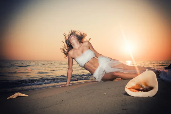 Schönes Mädchen mit weißem Stoff am Strand. — Stockfoto