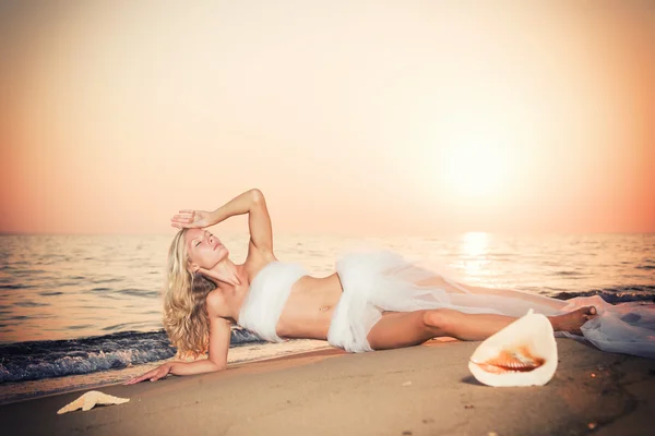 Vacker flicka med vitt tyg på stranden. — Stockfoto