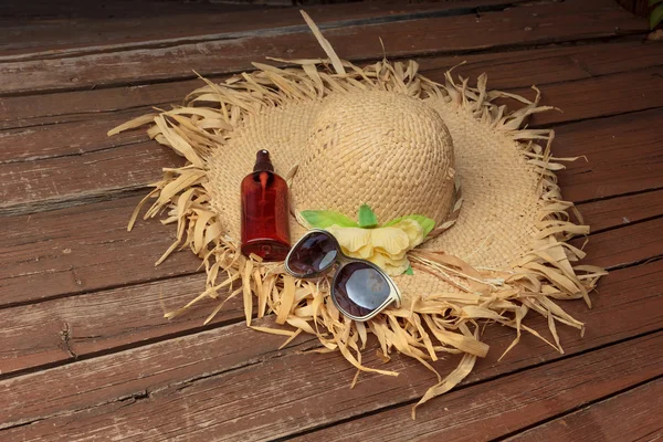 Hut, Sonnenbrille und Sonnencreme auf dem Deck — Stockfoto