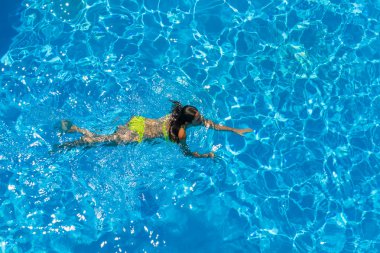 bir kızın rahatlatıcı bir yüzme havuzunda