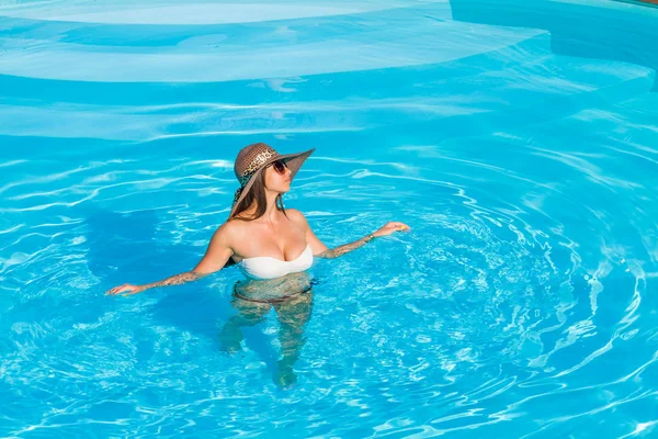 Une fille se relaxe dans une piscine — Photo