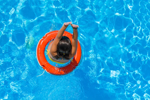 Uma menina está relaxando em uma piscina — Fotografia de Stock