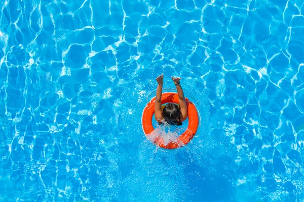 Uma menina está relaxando em uma piscina — Fotografia de Stock