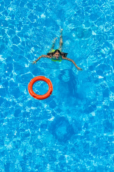 Une fille se relaxe dans une piscine — Photo