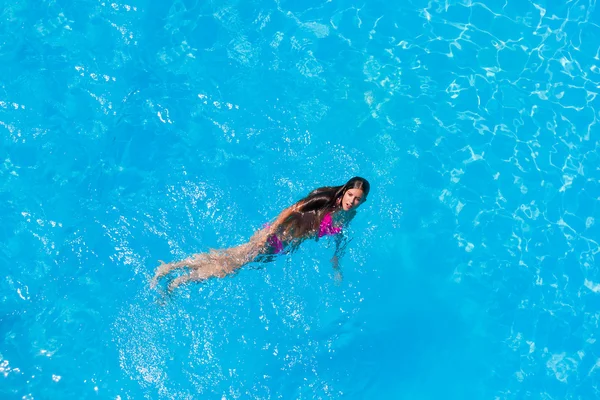 Une fille se relaxe dans une piscine — Photo