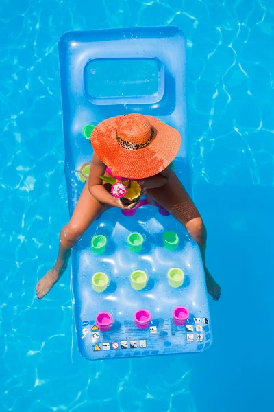 Uma menina está relaxando em uma piscina — Fotografia de Stock