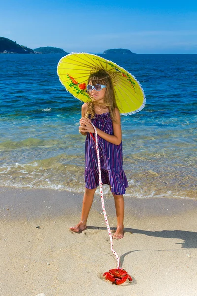 Onu Yengeç pet ile oynarken sahilde küçük kız — Stok fotoğraf