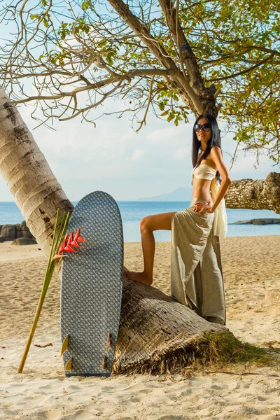 Mujer en sarong relajándose junto al cocotero — Foto de Stock