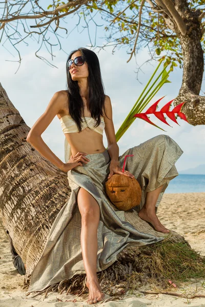 Mujer en sarong relajándose junto al cocotero — Foto de Stock