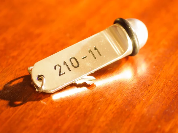 Hotel bell and key lying on the desk — Stock Photo, Image