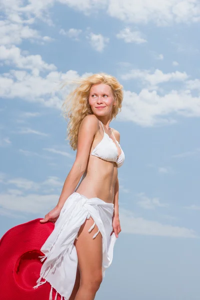 Beyaz bikinili kumsalda Malaya peştemâli tutan genç kadın — Stok fotoğraf