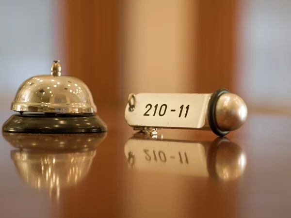 Hotel bell and key lying on the desk
