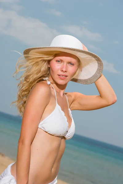 Beyaz bikinili kumsalda Malaya peştemâli tutan genç kadın — Stok fotoğraf