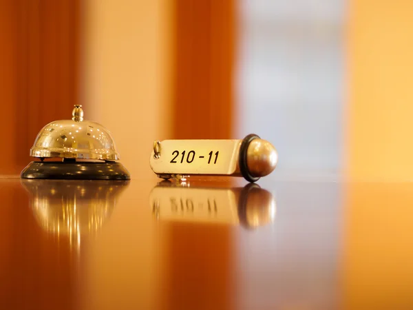 Hotelklingel und Schlüssel liegen auf dem Schreibtisch — Stockfoto