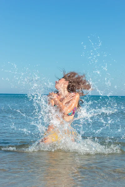 Szépség lány fröccsenő víz az óceánban — Stock Fotó