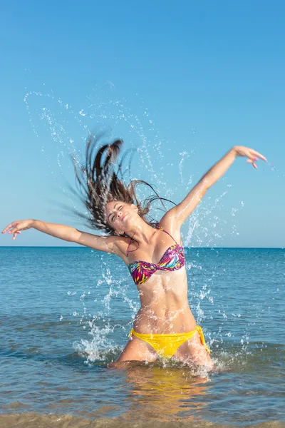 Krásy dívka modelu stříkající voda v oceánu — Stock fotografie