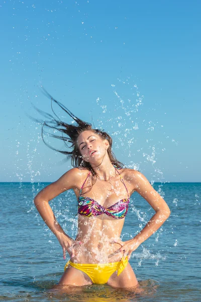 Skönhet modell flicka stänkande vatten i havet — Stockfoto