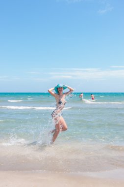 Sahildeki şapkalı kadın.