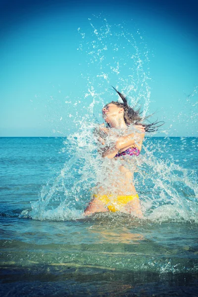 Bella donna salta fuori dal mare grande spruzzata — Foto Stock