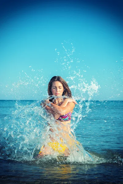 Mooie vrouw springt uit de zee grote plons — Stockfoto