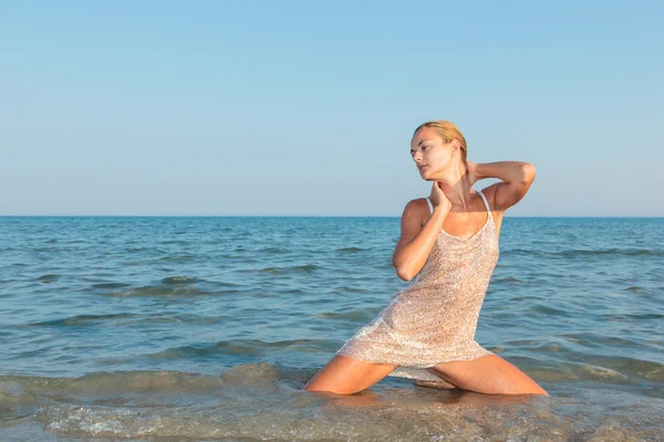 Jong sexy meisje in een bikini en natte shirt op het strand — Stockfoto