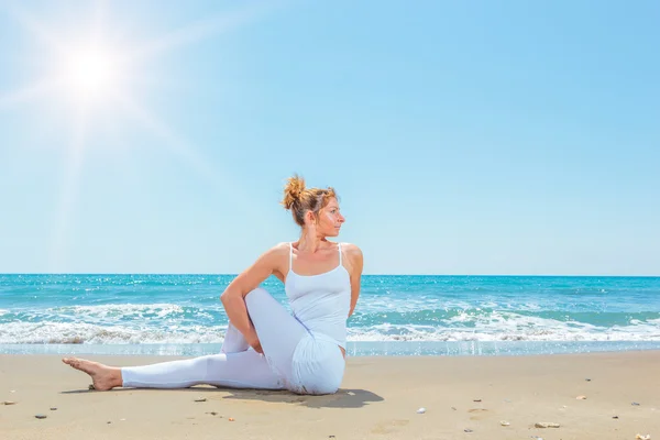 Beyaz kadını kumsalda Yoga uygulamak — Stok fotoğraf