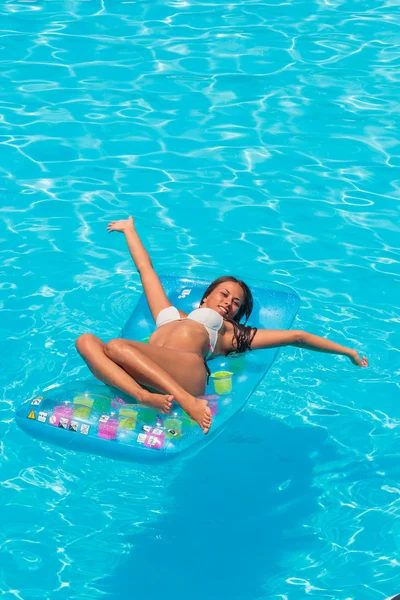 Una chica se relaja en una piscina Imágenes de stock libres de derechos