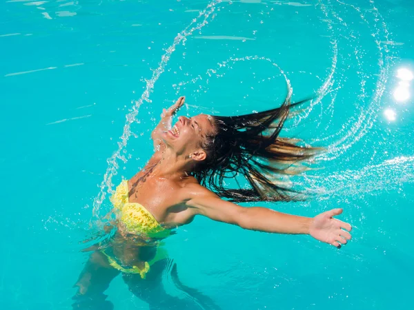 Uma menina está relaxando em uma piscina — Fotografia de Stock