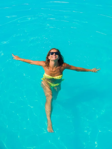 Une fille se relaxe dans une piscine — Photo