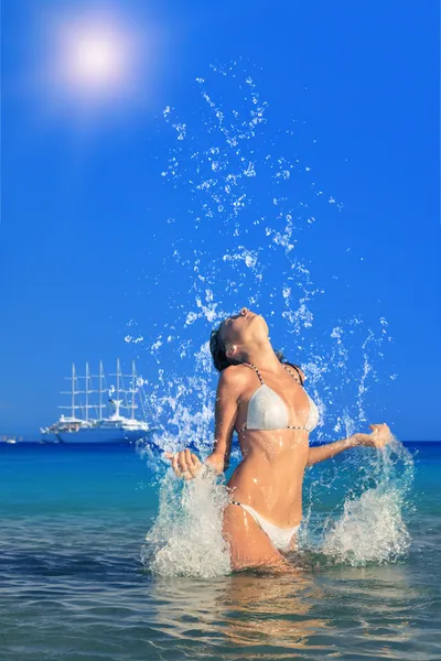 Vrouw springt uit de zee verlaten van een grote plons — Stockfoto