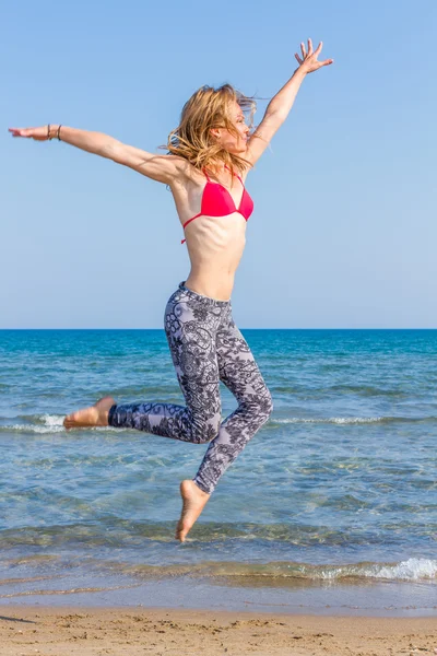 Jeune femme sautant dans l'eau — Photo