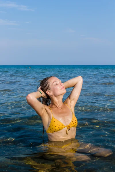 Mujer joven relajándose en la playa — Foto de Stock