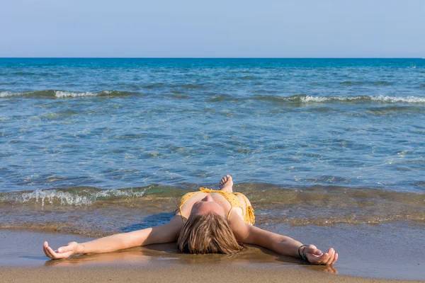 Mujer joven relajándose en la playa — Foto de Stock